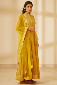 Yellow anarkali with placement floral motif work. Comes with pants and lace trim border dupatta.
Components: 3
Fabric: Silk, Georgette
Neckline: Round
Sleeve Length: Full
Color: Yellow
Embroidered, Printed

Concealed placket
Note: Belt worn by the model is not for sale - Aza Fashions Block Print Anarkali, Light Yellow Dresses, Yellow Anarkali, Quiet Elegance, Diwali Outfits, Designer Anarkali Suits, Traditional Attires, Casual Tunics, Indian Fashion Designers