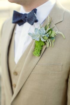 a man in a suit with a boutonniere and succulents on his lapel