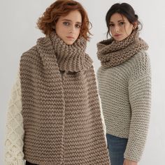 two women standing next to each other wearing knitted scarves and sweaters, one in brown and the other in beige