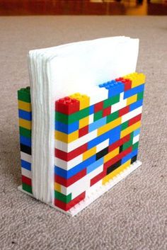 a book made out of legos sitting on the floor next to a pile of paper