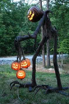 an outdoor halloween decoration with pumpkins hanging from it's branches