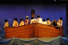 a group of people sitting on top of a boat in front of a blue wall