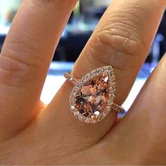 a woman's hand with a ring on it and an orange diamond in the middle