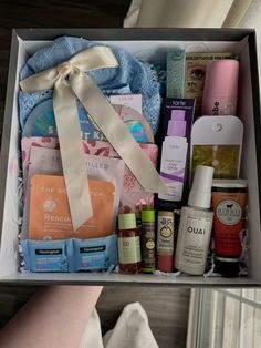 a woman's hand holding a box filled with personal care items