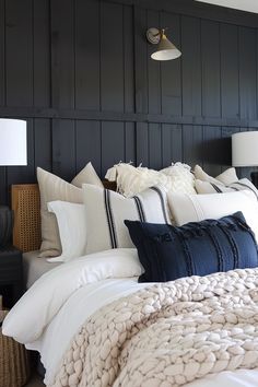 a bedroom with black walls and white bedding