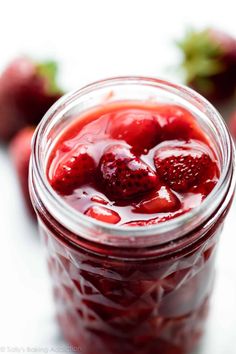 a glass jar filled with liquid and strawberries