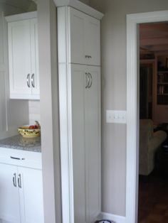 a kitchen with white cabinets and granite counter tops in the middle of an open doorway