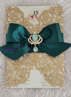 a wedding card with a green bow on top of it and gold lace around the edge