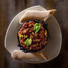 a plate with some food on top of it and a napkin in the shape of a hand