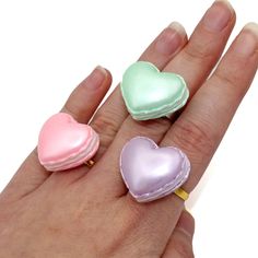 Perfect for Valentine's Day or any day! A pastel pearly finish heart shaped macaron with whipped cream center. You can choose your favorite color from: Pink, Mint Green, or Purple. These rings are adjustable and each macaron is about 1" wide and comes securely attached to an adjustable ring band in gold plated or silver tone (fits most adult sizes). More matching Macaron Jewelry available just search "Heart Macaron"**Made to Order** will take about 2 weeks to make before shipment.Every order com Kawaii Outfit Ideas, Pastel Heart, Donut Ring, Pink Birthday Cakes, Miniature Food Jewelry, Kawaii Jewelry, Polymer Clay Miniatures, Food Jewelry, Clay Miniatures