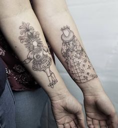 two people with matching tattoos on their arms, one holding the other's hand