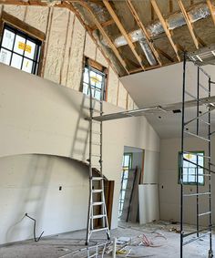 an unfinished room with scaffolding and ladders in the process of remodeling