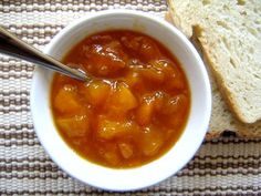 there is a bowl of soup and a piece of bread next to it on the table