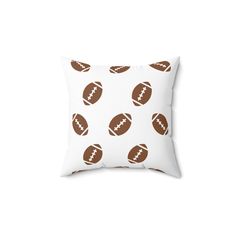 a white pillow with brown footballs on it