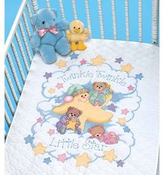 a baby crib with two teddy bears on it and a blanket that says twinkle twinkle little star