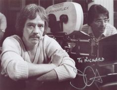 black and white photograph of two men sitting in front of a camera