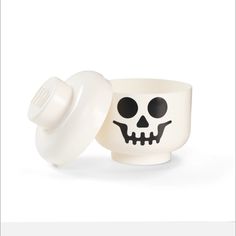 a white cup with a skull face on it