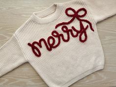 Made to order hand embroidered Christmas bow sweater.  Perfect for holiday photos, holiday parties and Christmas tree farms! Switch out "merry" for any phrase or name.  All words will be written in cursive unless you specify otherwise. These are handwritten, no two sweaters will look the same!  For reference, the "merry" sweater is done on a creamy sweater with red extra chunky yarn.  PERSONALIZATION Please include the color of sweater, name/word you want on the sweater (case sensitive, I will make the sweater exactly the way you type it), yarn thickness (thin, chunky or extra chunky) and yarn color.  Please visit my instagram @tatumthreads_ for more sweater designs/options and reach out with any questions!  Any name longer than 7 letters will typically need to be done in thin yarn.  SIZIN Big Sis Sweater, Diy Christmas Sweater Embroidery, Christmas Embroidered Sweaters, Kids Embroidery Ideas, Hand Embroidered Christmas Sweater, Embroidery On Sweaters, Christmas Sweater Embroidery, Merry Sweater