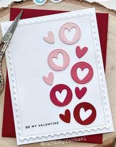 a valentine's day card with scissors and paper hearts