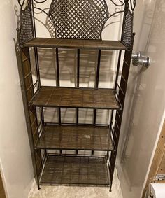 a metal shelf with wicker baskets on the top and bottom, in a bathroom