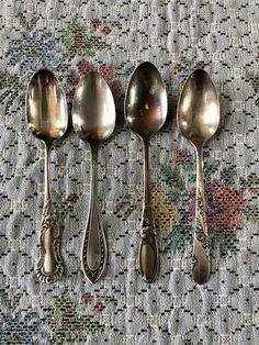 four spoons are lined up on a tablecloth