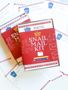 two small mail kits sitting on top of each other next to envelopes and paper