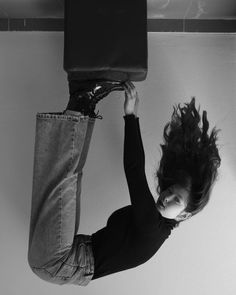 a woman hanging upside down with her hair in the air