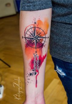 a person with a compass tattoo on their arm and hand, painted in watercolors