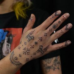 a woman's hand with tattoos on it