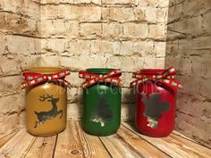 three painted jars with christmas decorations on them