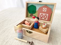 an open wooden box with figurines in it