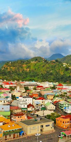 an aerial view of a small town with mountains in the backgrouds and clouds in the sky