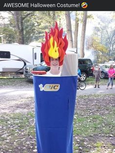 a person in a costume made to look like a fireman's head is on top of a blue trash can