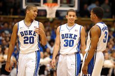 two men in blue and white uniforms are on the court with one man yelling at another