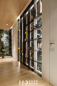 an empty room with many shelves and vases on the wall next to each other