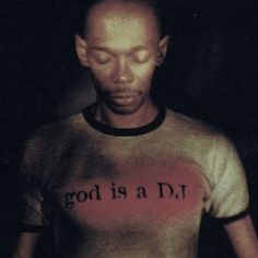 a man wearing a t - shirt with the words god is a dj on it