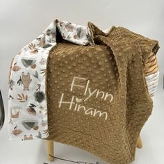 a blanket that is sitting on top of a chair with the words flinn hramn written on it