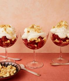 three desserts in small glasses on a table