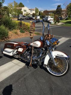 a white and brown motorcycle parked on the side of a road next to a parking lot