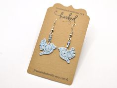 These unique bluebird earrings are so delicate and lovely. This sky blue color will add a cheerful touch to any outfit. The beads are iridescent, a mix of purple and blue, and they add just a touch of sparkle. Bluebirds are a symbol of joy, hope, and good fortune. You'll feel the promise of good times to come every time you put these on. And because they're made with cotton thread, they're feather-light and comfortable for daily wear. You'll almost forget you're wearing them, except that you'll Cute Handmade Light Blue Earrings, Jewelry Aesthetic Earrings, Blue Bird Jewelry, Origami Leaves, Aesthetic Earrings, Sky Blue Color, Jewelry Aesthetic, Lace Earrings, Bird Jewelry