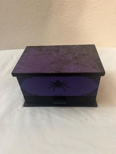 a purple and black box with a spider on it