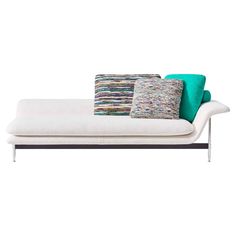 a white couch with three pillows on it's back and two different colored cushions