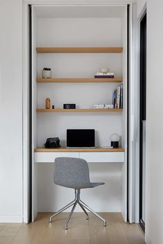 a chair sitting in front of a desk with a laptop on it