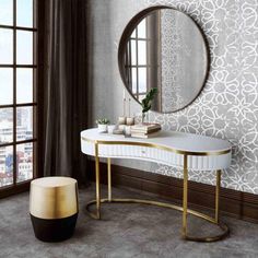 a white and gold console table with a round mirror on it in front of a window