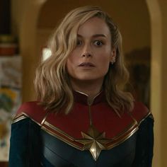 a woman in a captain marvel costume looking at the camera with an intense look on her face