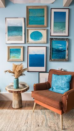 a living room with blue walls and pictures hanging on the wall, including a chair