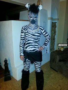 a man dressed up as a zebra standing in front of a refrigerator