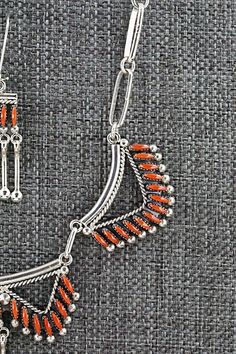 This intricately crafted coral and sterling silver necklace and earrings set was made by Zuni silversmith Stewart Nakatewa. The back of the necklace is signed.Necklace: 15"Length: 1 1/4"Width: 2 3/8"Earrings:Length: 1 1/2"Width: 3/8"Free shipping on all orders! We ship with USPS and always include tracking. All orders ship within a day of payment.Returns are accepted up to 30 days after you receive your order. Just send us a message. Our shop offers cash back or store credit. The item must be re Red Sterling Silver Necklace With Matching Earrings, Southwestern Sterling Silver Necklace With Oxidized Finish, Red Sterling Silver Jewelry With Inlay, Southwestern Multi-strand Necklaces As Gift, Handmade Silver Jewelry With Red Coral, Red Southwestern Sterling Silver Necklace, Southwestern Multi-stone Sterling Silver Necklace, Southwestern Style Nickel-free Silver Necklace, Multi-strand Red Coral Necklace With Polished Beads