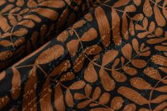 the fabric is black and brown with leaves on it