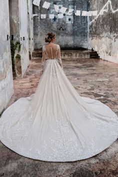 a woman in a wedding dress is standing on the floor with her back to the camera